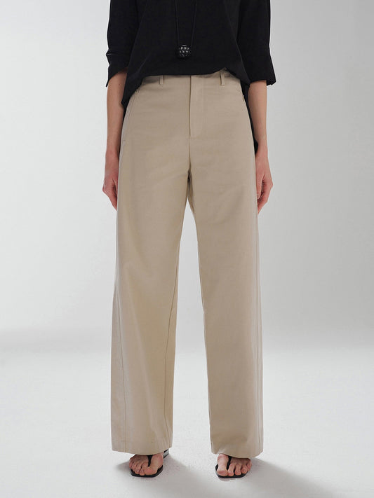 Woman wearing Arkin Studio pear friendly curved leg pants in khaki and a black top, with arms down at her sides, standing facing the camera, main view on a white background