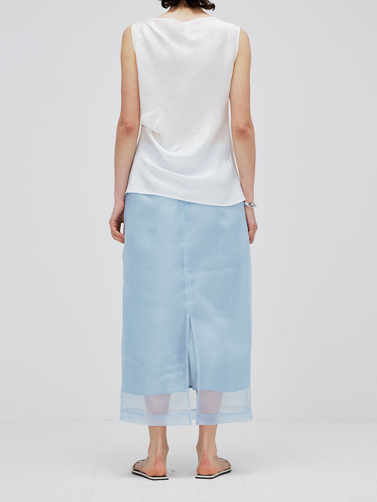 Woman wearing Arkin Studio high-waist light blue mesh two-layer midi skirt, back view, on white background
