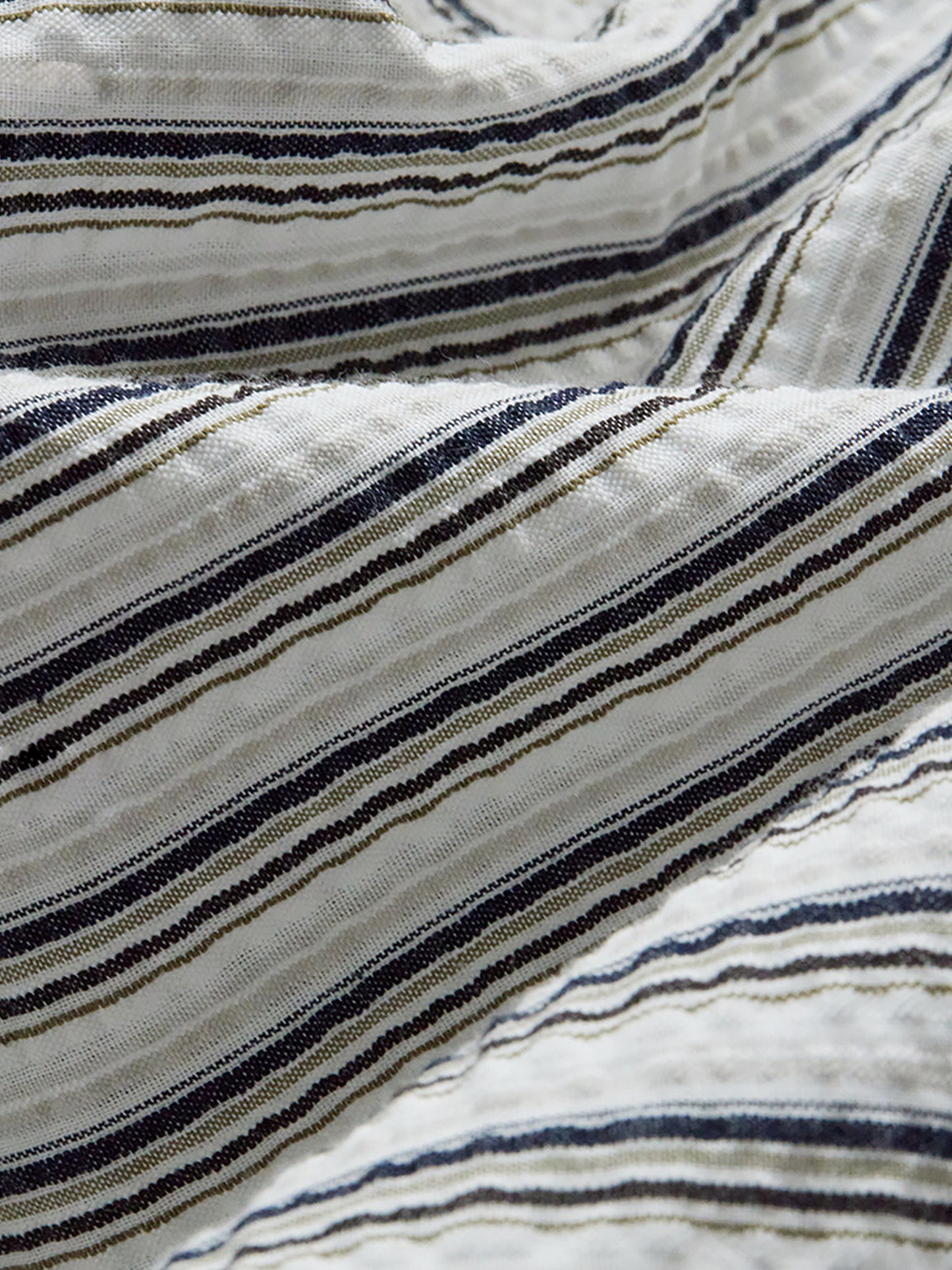 Arkin Studio close-up of striped fabric with black and beige lines on a white background