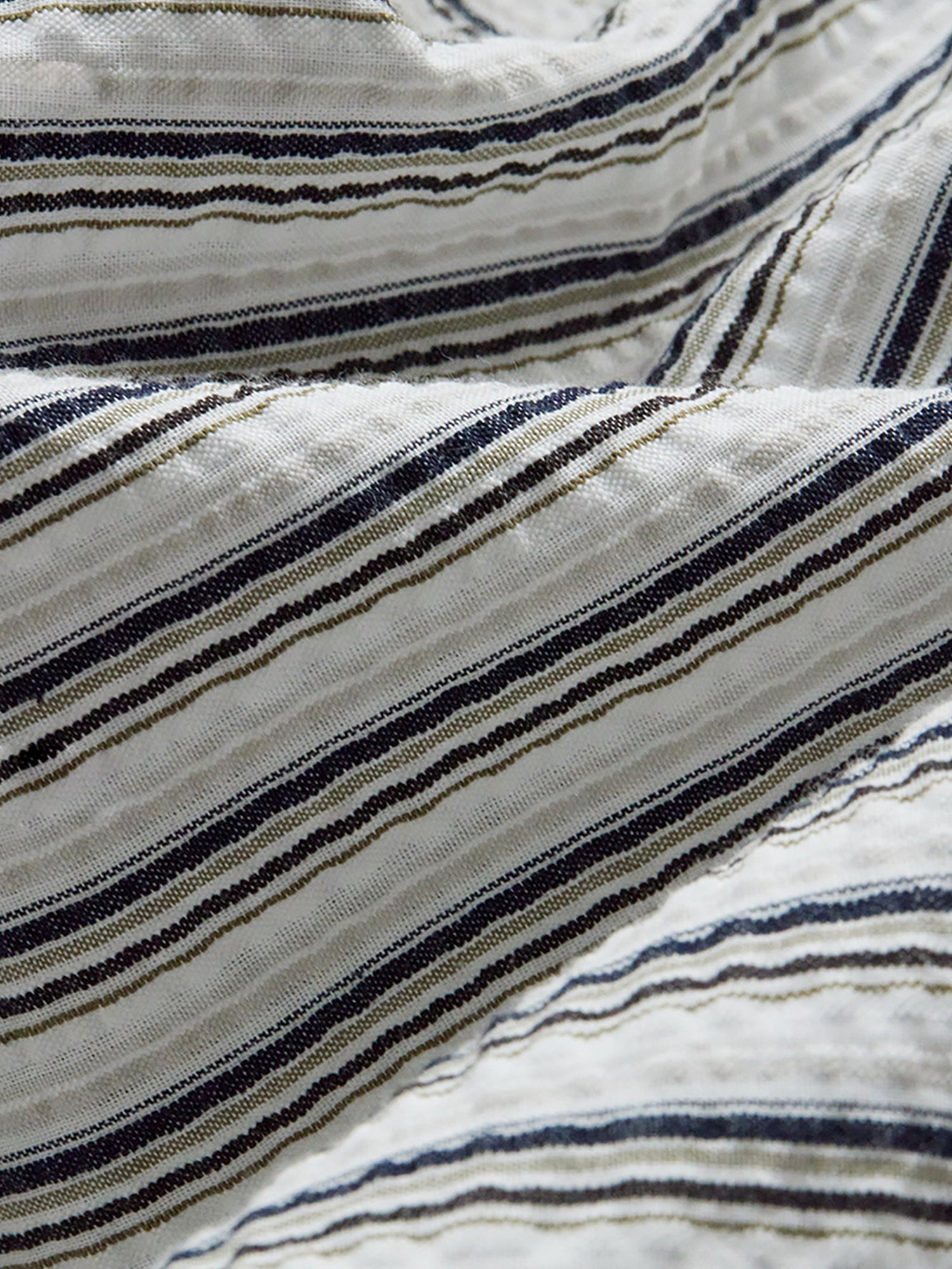 Arkin Studio close-up of striped fabric with black and beige lines on a white background